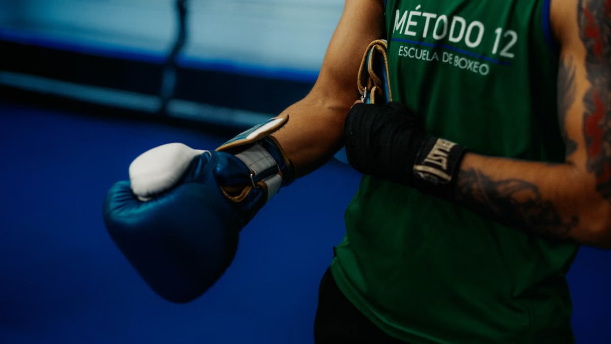 Boxer tightening gloves during training in Buenos Aires gym, showcasing discipline and focus.